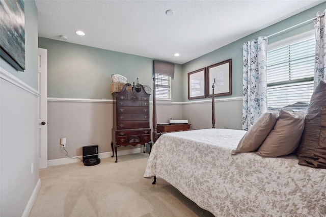 bedroom with a textured ceiling and light carpet