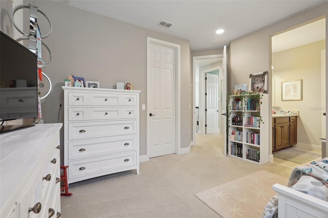 bedroom featuring light colored carpet and connected bathroom