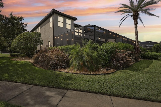 exterior space featuring a lanai and a lawn