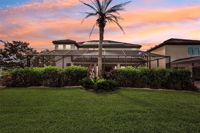 exterior space featuring glass enclosure and a yard