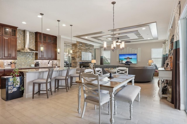 dining space with crown molding, plenty of natural light, sink, and a notable chandelier