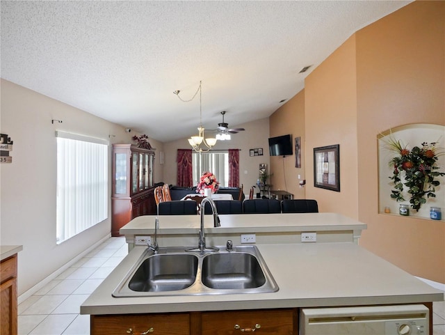 kitchen with ceiling fan, sink, lofted ceiling, light tile patterned floors, and a kitchen island with sink