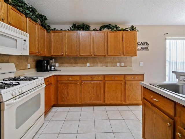 kitchen featuring light tile patterned flooring, decorative backsplash, white appliances, and a textured ceiling