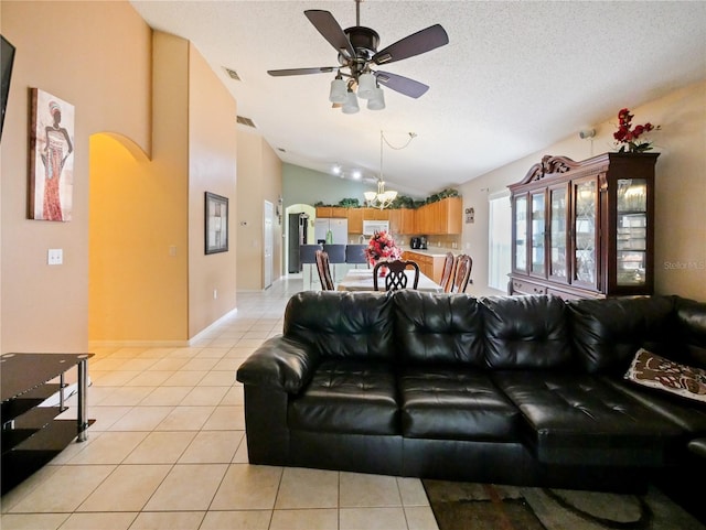 tiled living room with a textured ceiling, ceiling fan with notable chandelier, and vaulted ceiling