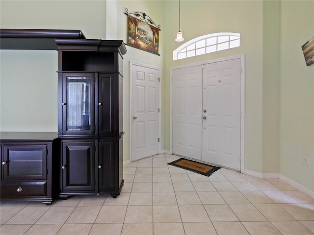 tiled entryway with a towering ceiling