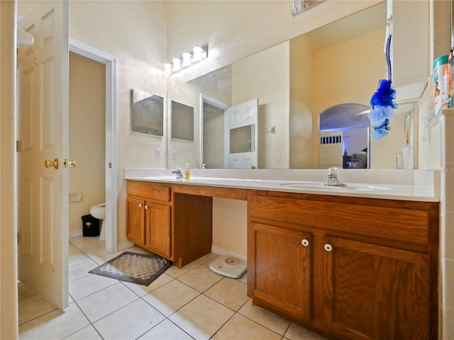 bathroom with tile patterned floors, toilet, and dual bowl vanity