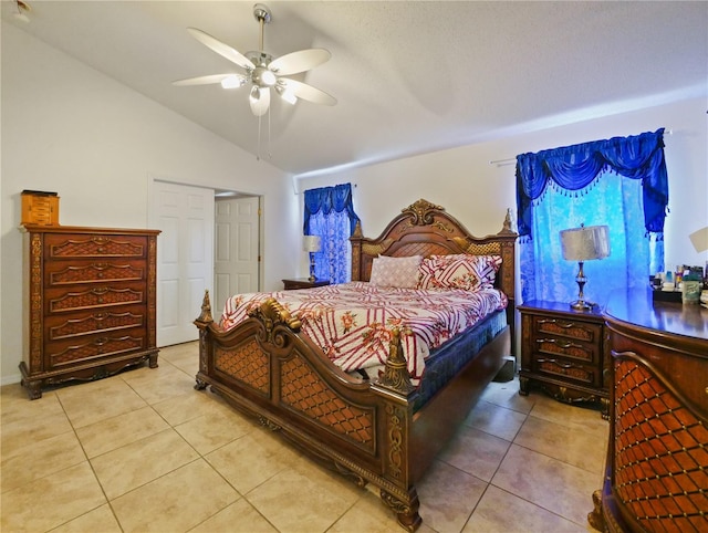 bedroom featuring light tile patterned flooring, ceiling fan, lofted ceiling, and a closet