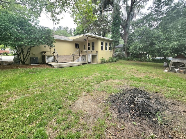 view of yard featuring central AC, ceiling fan, and a deck