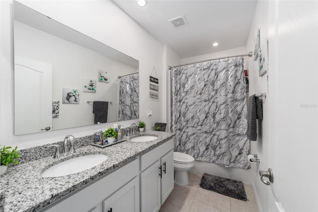 bathroom featuring double sink vanity, toilet, and tile patterned flooring