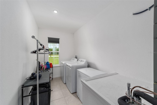 clothes washing area with light tile patterned flooring and washer and dryer