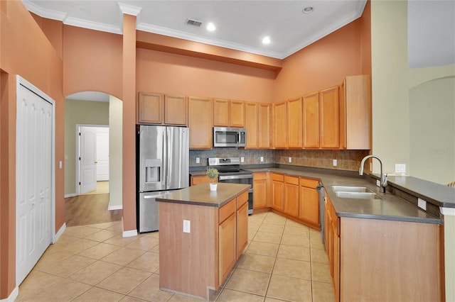 kitchen with light hardwood / wood-style flooring, backsplash, a center island, appliances with stainless steel finishes, and sink