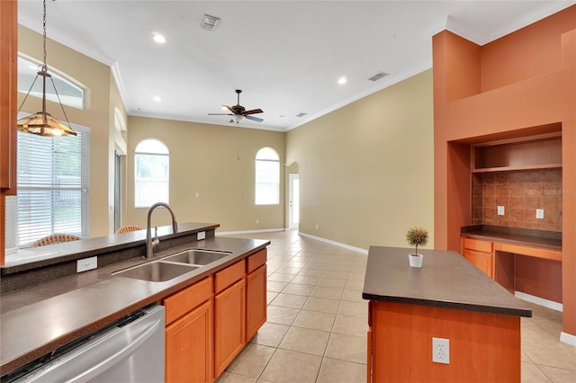 kitchen featuring tasteful backsplash, dishwasher, a kitchen island, ceiling fan, and sink