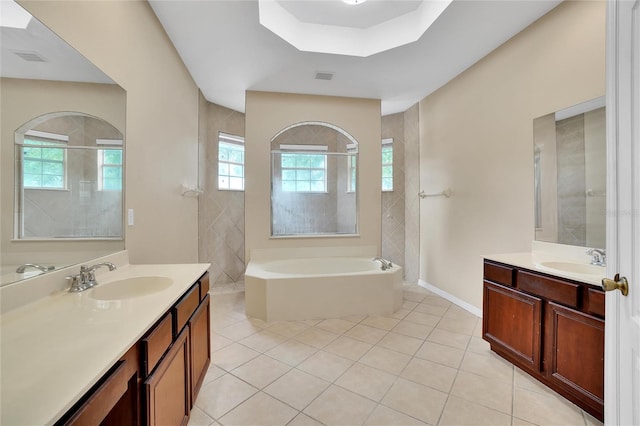 bathroom featuring a tub, tile patterned floors, dual bowl vanity, and plenty of natural light