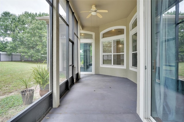 unfurnished sunroom with ceiling fan and plenty of natural light