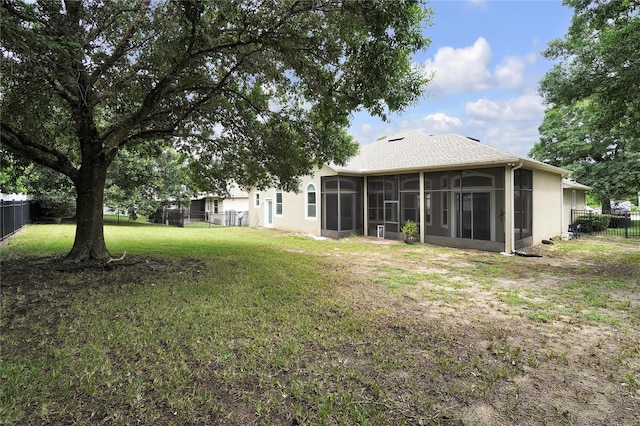 back of house with a yard and a sunroom