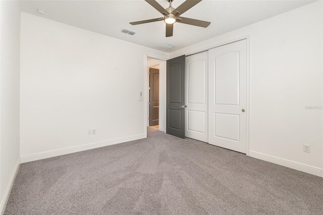 unfurnished bedroom with carpet, ceiling fan, and a closet