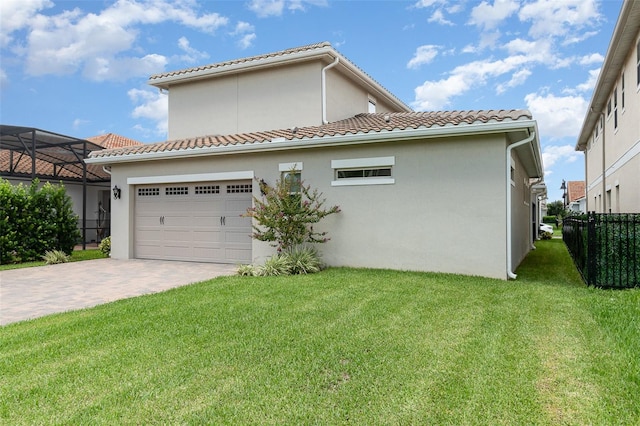 view of side of property featuring a lanai, a yard, and a garage