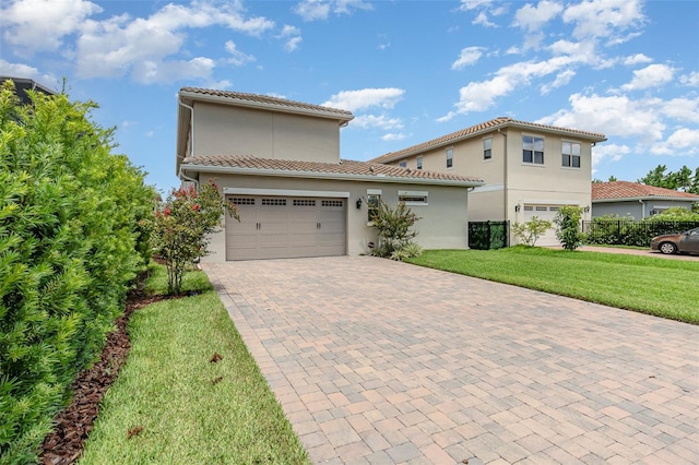 mediterranean / spanish home featuring a front yard and a garage