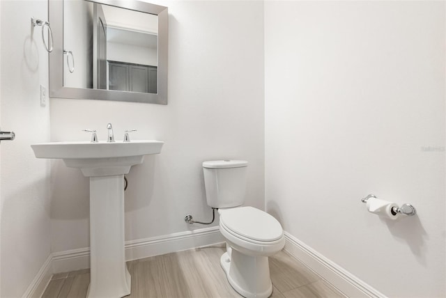 bathroom with hardwood / wood-style floors and toilet