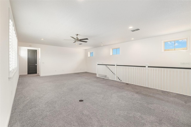 spare room featuring a healthy amount of sunlight, carpet flooring, and ceiling fan