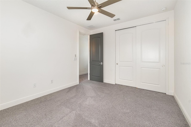 unfurnished bedroom featuring ceiling fan, a closet, and carpet