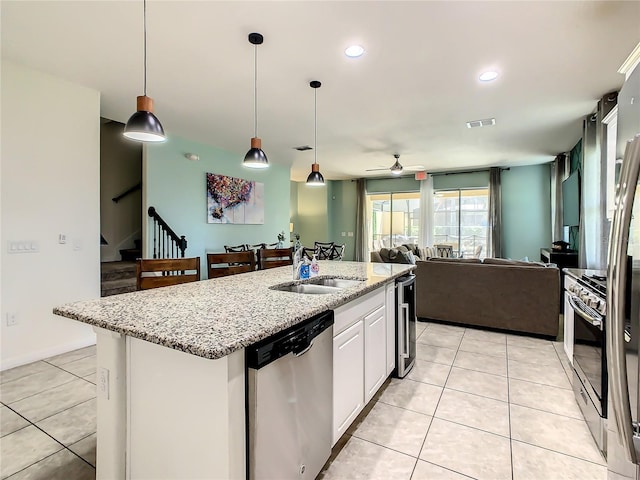 kitchen with sink, light tile patterned floors, white cabinets, and appliances with stainless steel finishes