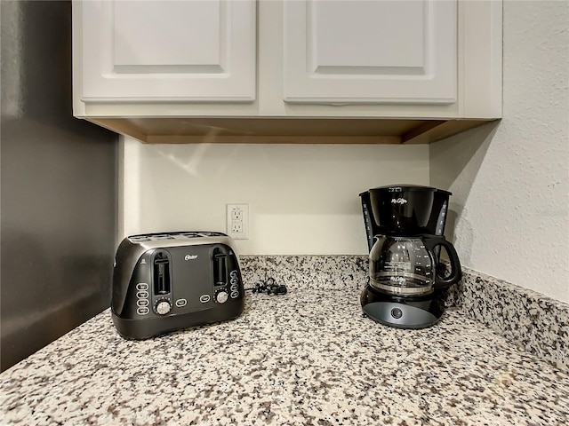 room details featuring light stone countertops and white cabinets