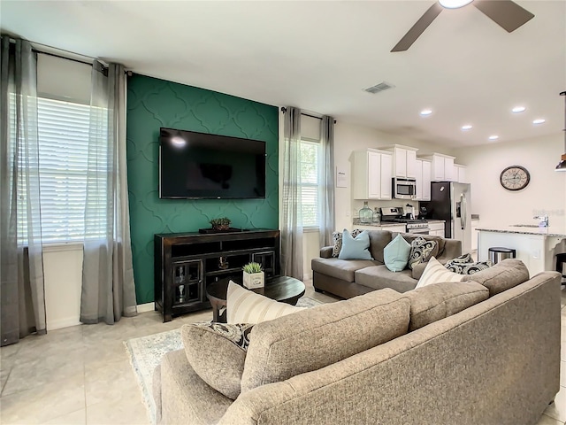 tiled living room featuring sink and ceiling fan