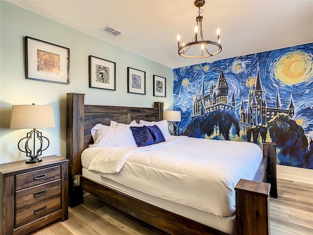 bedroom featuring a notable chandelier and light hardwood / wood-style flooring