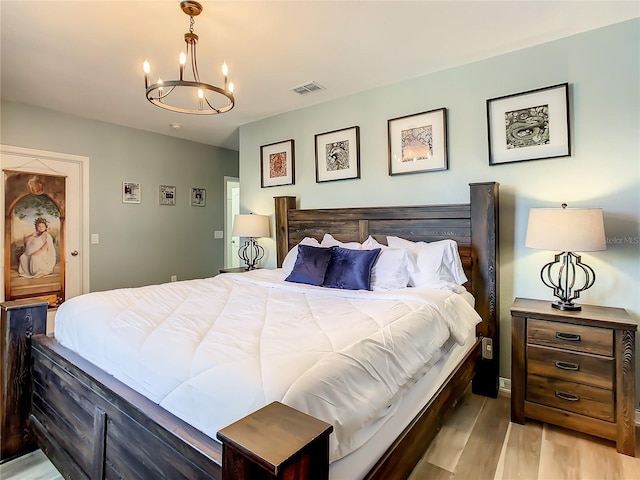 bedroom featuring hardwood / wood-style flooring and a notable chandelier