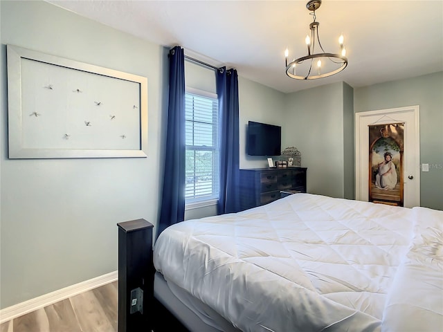 bedroom with wood-type flooring and a chandelier