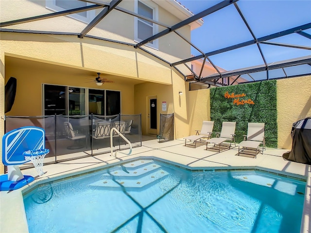 view of swimming pool featuring ceiling fan, a water slide, a patio area, and glass enclosure