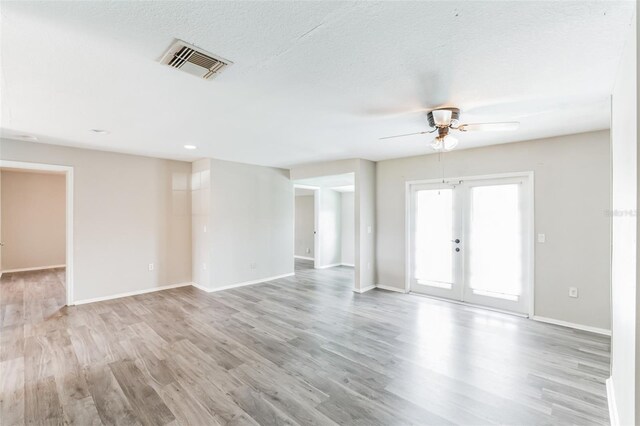 unfurnished room with a textured ceiling, french doors, ceiling fan, and light hardwood / wood-style floors