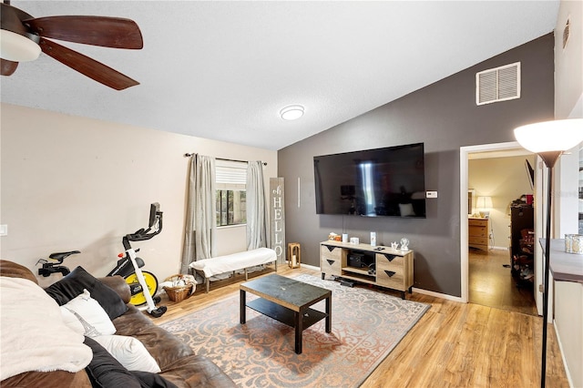 living room with lofted ceiling, light wood-type flooring, and ceiling fan