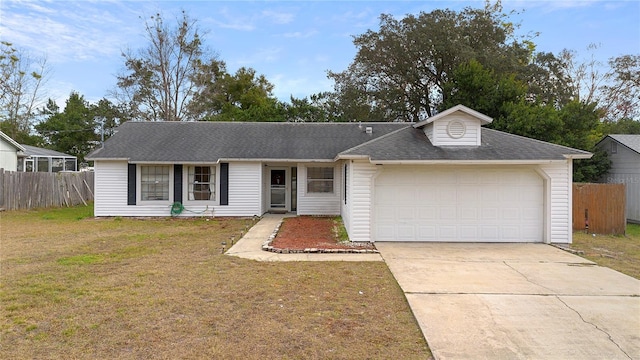 ranch-style home featuring a garage, fence, driveway, and a front yard