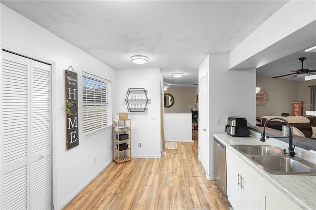 kitchen with ceiling fan, dishwasher, sink, white cabinetry, and light hardwood / wood-style flooring