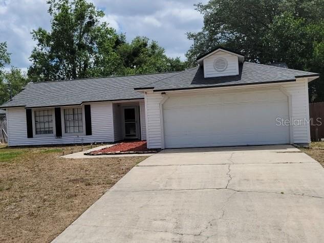 view of front of house featuring an attached garage, a shingled roof, and concrete driveway
