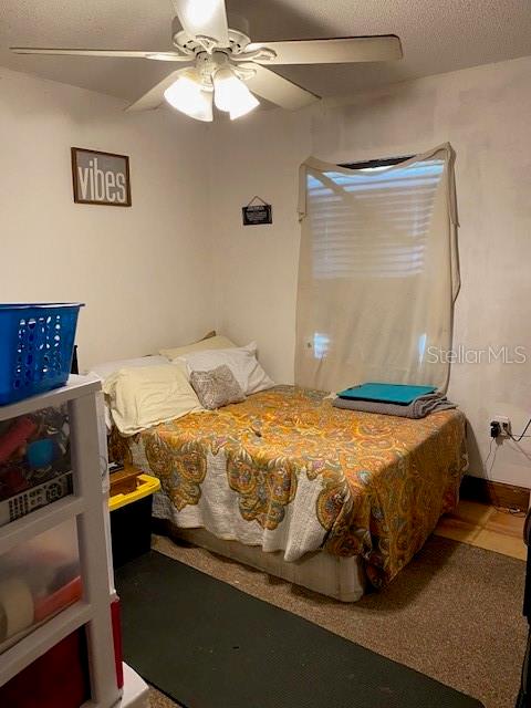 bedroom with tile patterned flooring, ceiling fan, and a textured ceiling