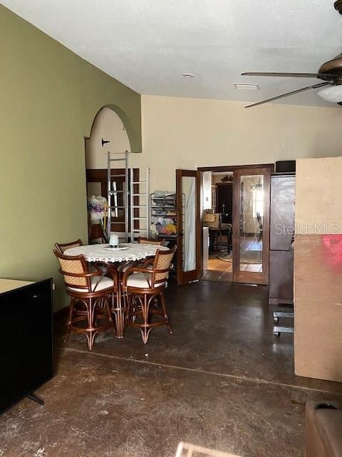 dining area with ceiling fan and concrete floors