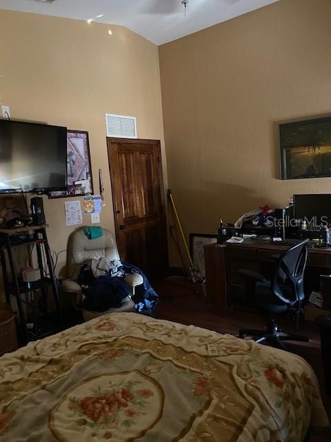 bedroom featuring hardwood / wood-style flooring and lofted ceiling