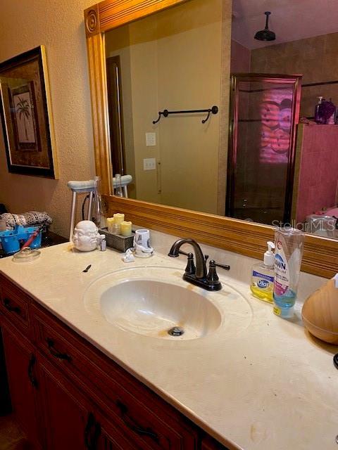 709 N Disston, Tavares, FL 32778 - bathroom with a stall shower, vanity, and a textured wall