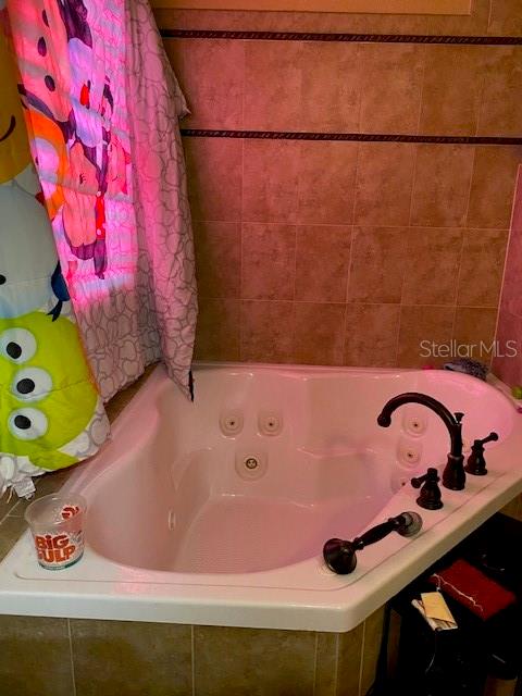 bathroom featuring a relaxing tiled tub