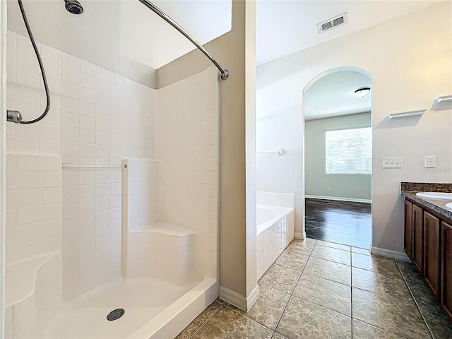 bathroom with vanity and shower with separate bathtub