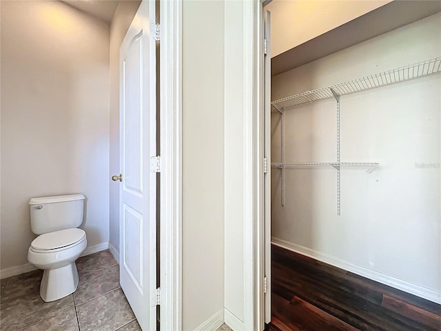 bathroom with toilet and hardwood / wood-style flooring