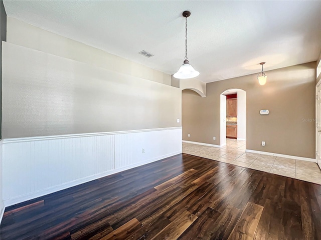 empty room featuring a textured ceiling and light hardwood / wood-style flooring