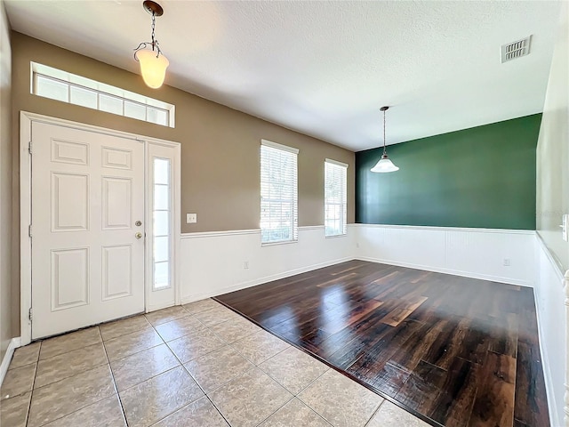 foyer entrance featuring a textured ceiling and light wood-type flooring