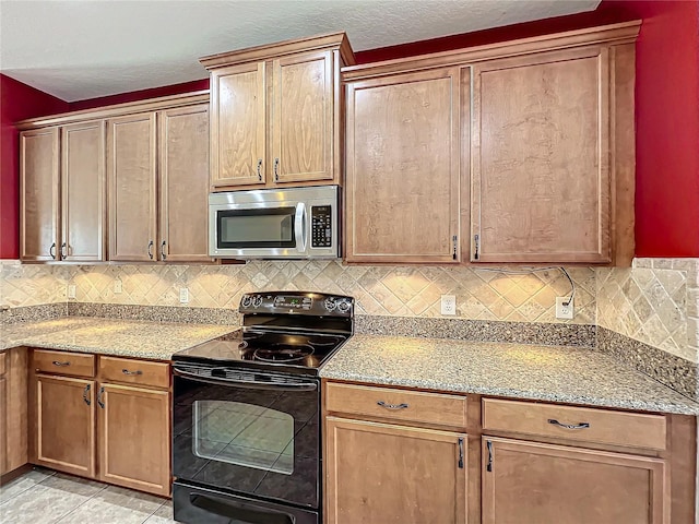 kitchen with decorative backsplash, light stone counters, black electric range, and light tile patterned floors