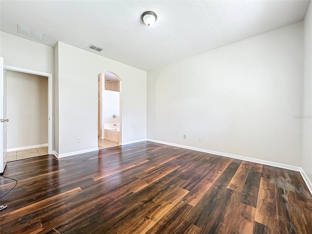 unfurnished room with dark wood-type flooring