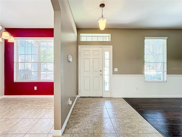 entryway with tile patterned flooring, a textured ceiling, and plenty of natural light