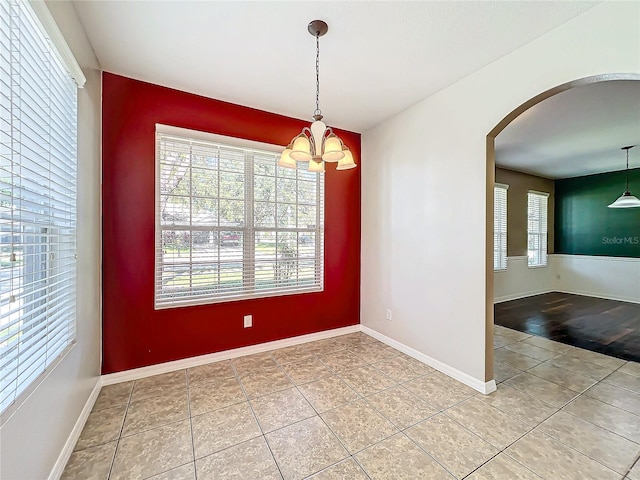 unfurnished dining area featuring wood-type flooring and an inviting chandelier